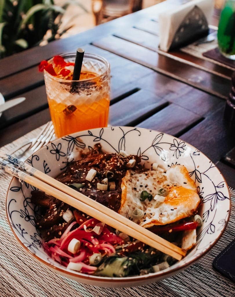 A vibrant dish served with a refreshing cocktail on a wooden table setting in Nairobi, Kenya.