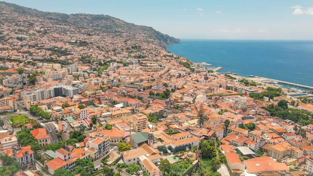 Explore the vibrant aerial view of Funchal, Madeira, showcasing its coastal urban landscape and scenic beauty.