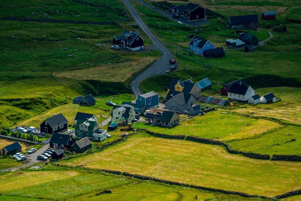 Aerial photo of a charming rural village with vibrant fields and scattered houses.